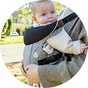 A baby in a Dreambaby Journey Baby Carrier (3 Way Facing) Grey.