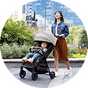 A mother out with her baby in a Graco Myavo Quick-Folding Travel Stroller - Midnight.