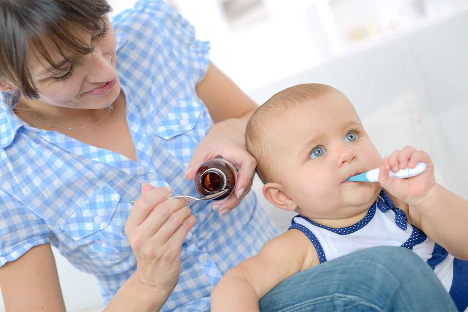 A baby using an oral thermometer.
