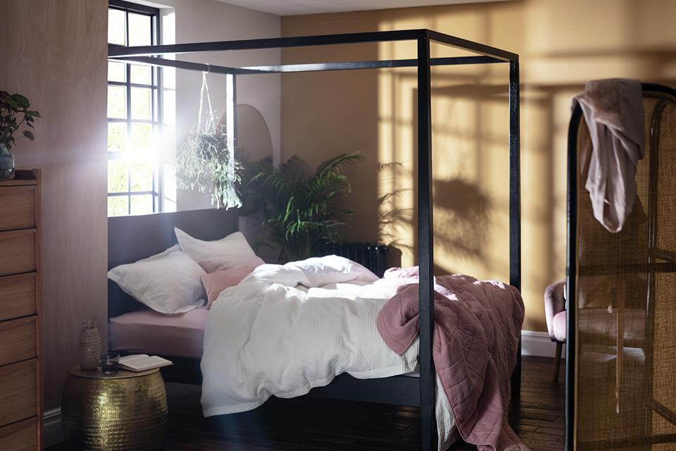 Poster bed in bedroom with accessories.