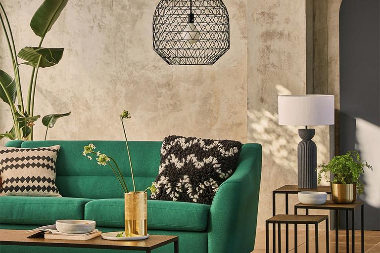 Green sofa in living room with black and wooden accessories.
