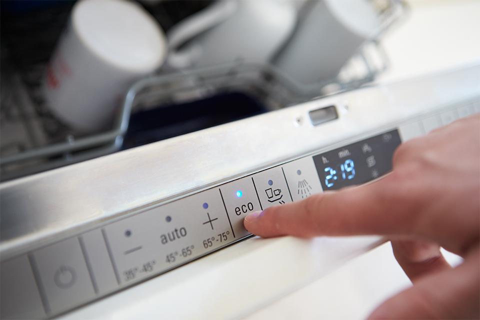 Man setting Economy Cycle on a dishwasher.