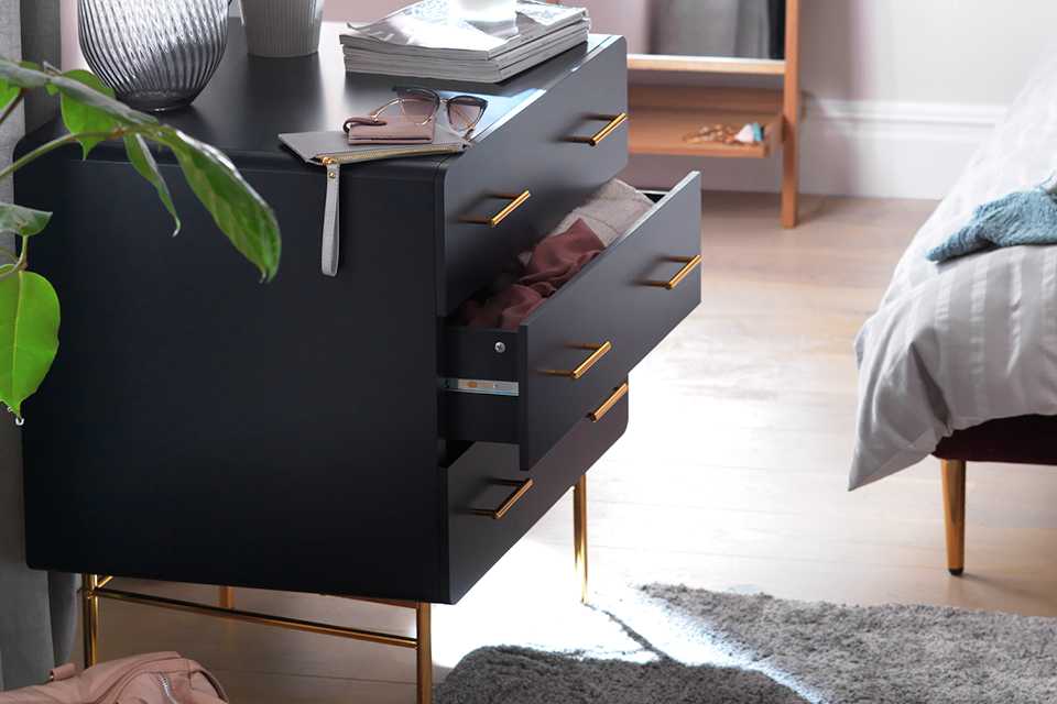 Midnight blue three drawer chest of drawers in bedroom.
