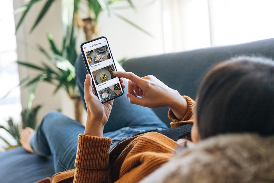 A woman browses the internet on a smartphone.