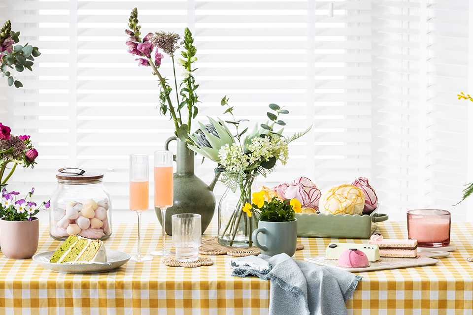 A dining table decorated with vases, serveware and tableware.