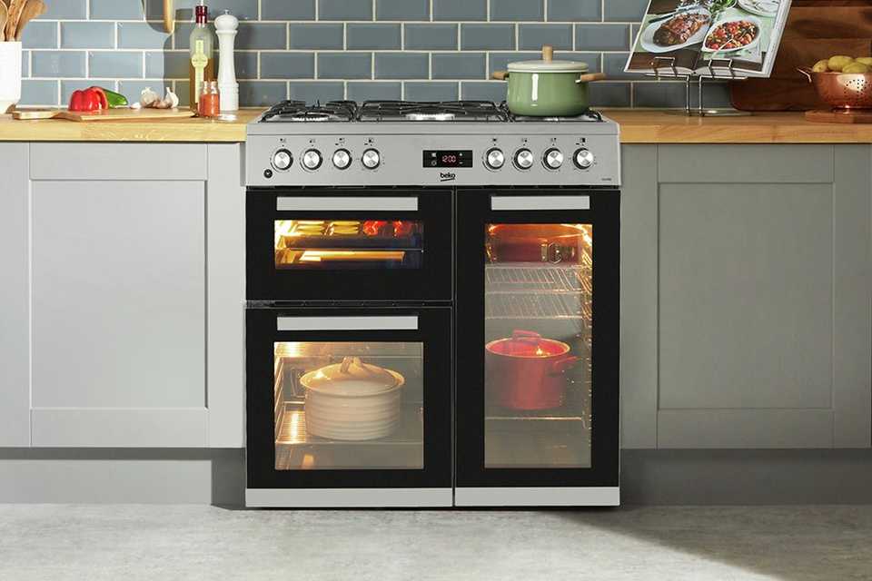 Beko 90cm stainless steel dual fuel range cooker in a kitchen setup.