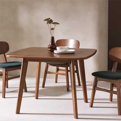 Wooden didning table with matching chairs with black cushion pads insiraed by mid century furniture trend.