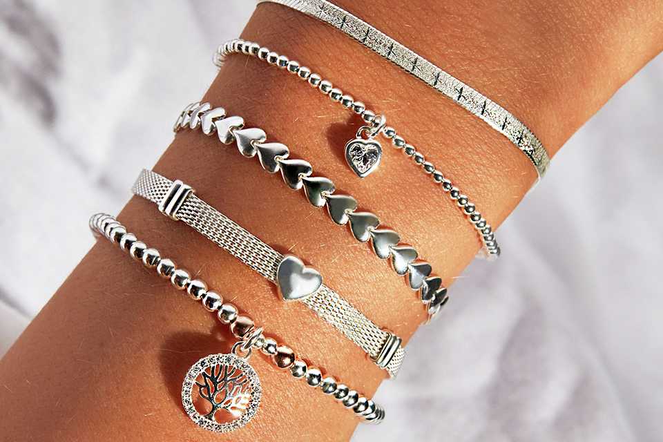 A person wearing simply silver sterling silver 925 heart stretch bracelets.
