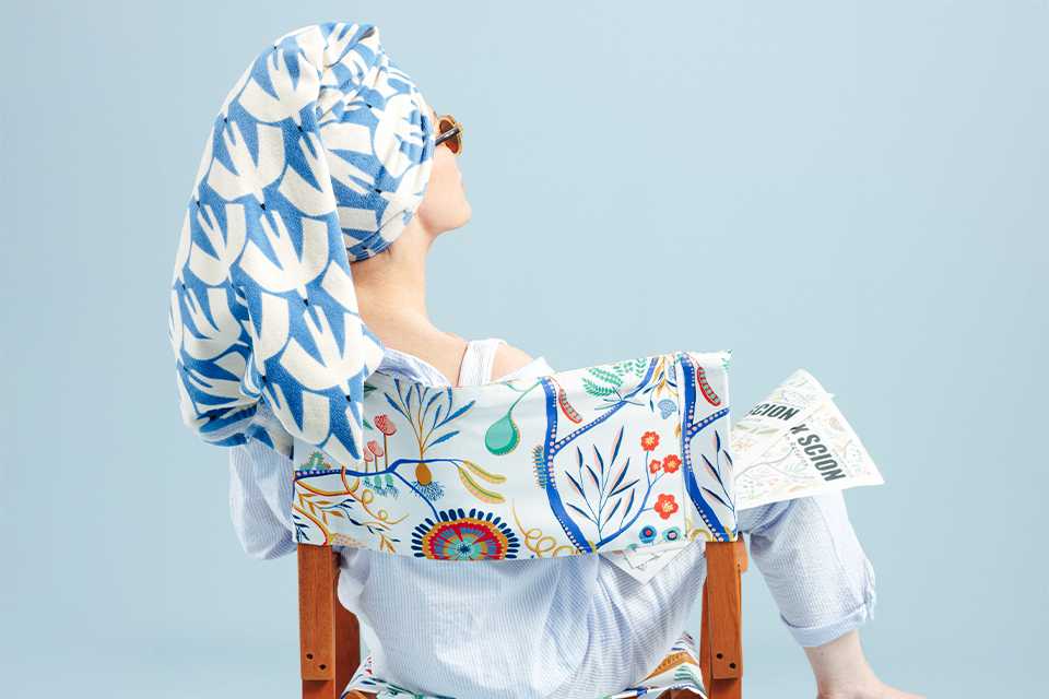 Green wire garden bench with floral seat cushion.