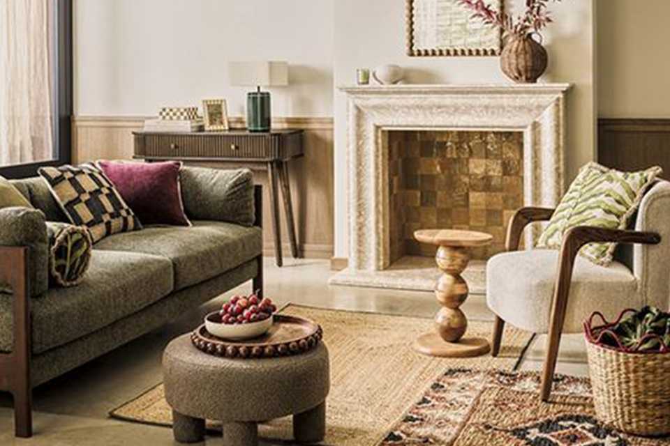 Living room scene with bobble wooden trays and frames and green velvet sofa with fuschia accesories.