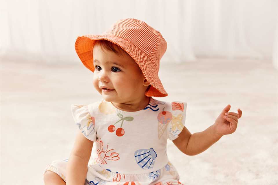 baby in a summer hat and dress