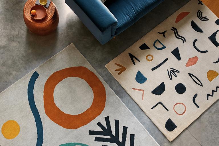A blue patterned rug on a wooden floor.