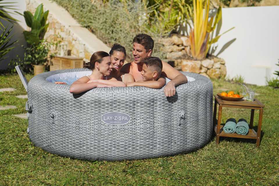 A family spending quality time outdoors on a sunny day in a Lay-Z-Spa Honolulu AirJet™ hot tub