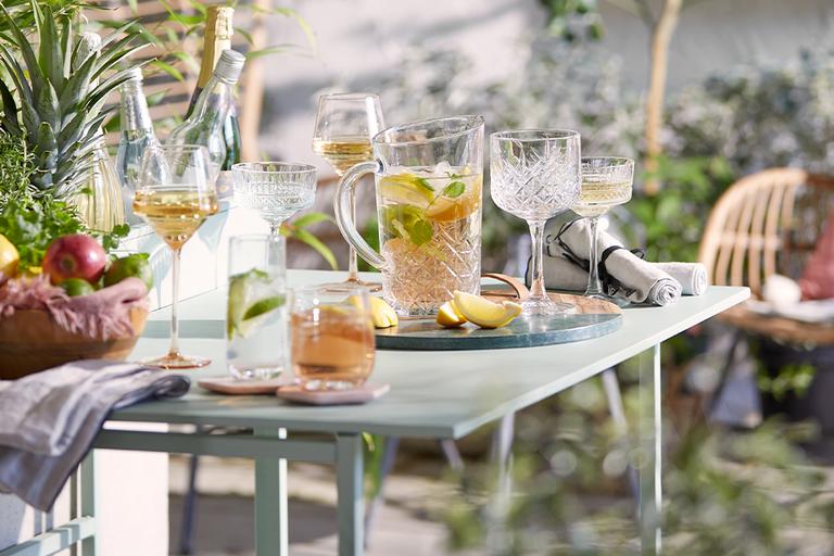 Outdoor table with glassware and cocktails.