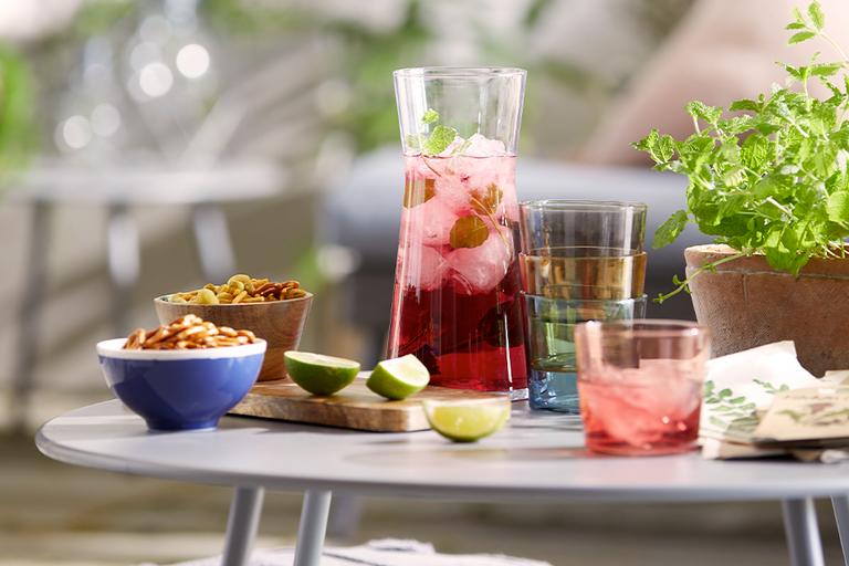 Colourful glassware and tableware in garden.