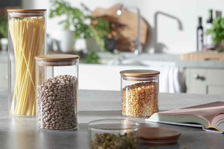 Three clear storage containers with different ingredients on top of counter.
