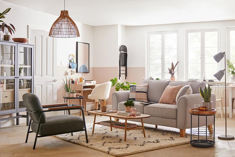 A living room with a cream sofa, mid-century coffee table, and a fluffy rug.