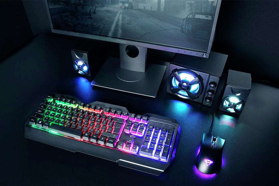 A gaming keyboard and mouse next to a monitor.