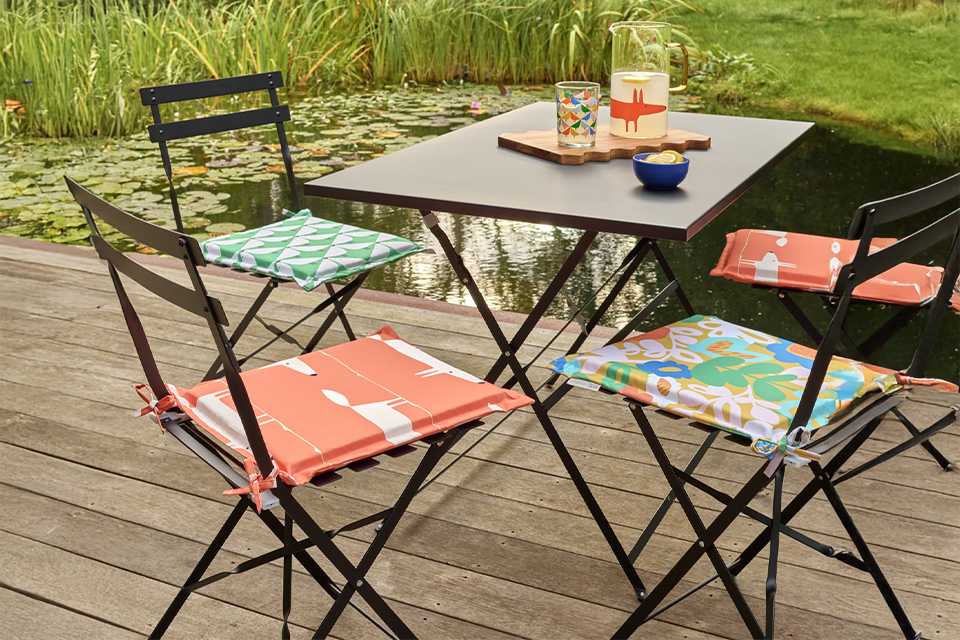 Habitat x Scion Pack of 2 Mr Fox Garden Chair Cushions in a garden.