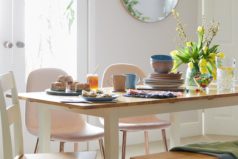 Dining room with oak and white dining table and pink velvet chairs.