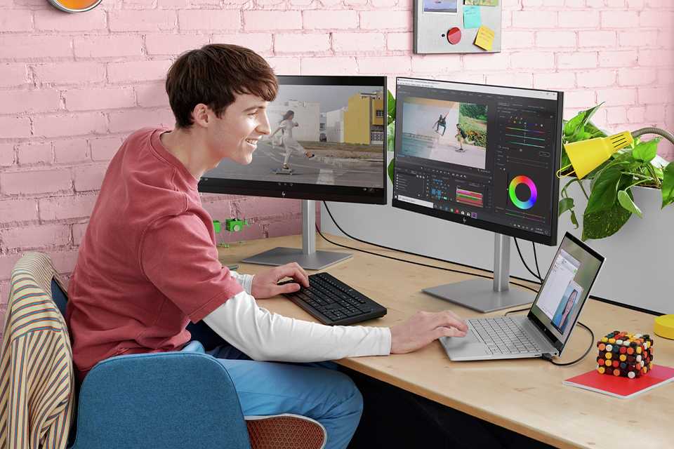 A boy using a PC and a laptop at home.