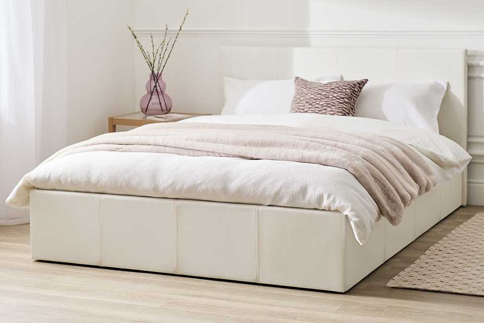 A white Argos Home Lavendon small double end lift ottoman bed in a bedroom.