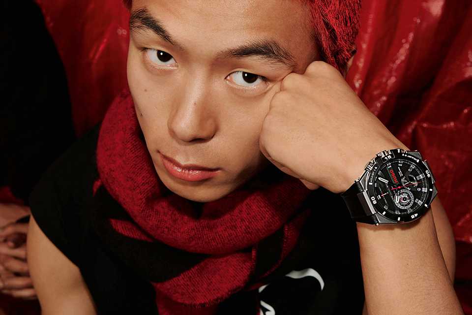 A male model wearing a Hugo men's black strap leather watch.