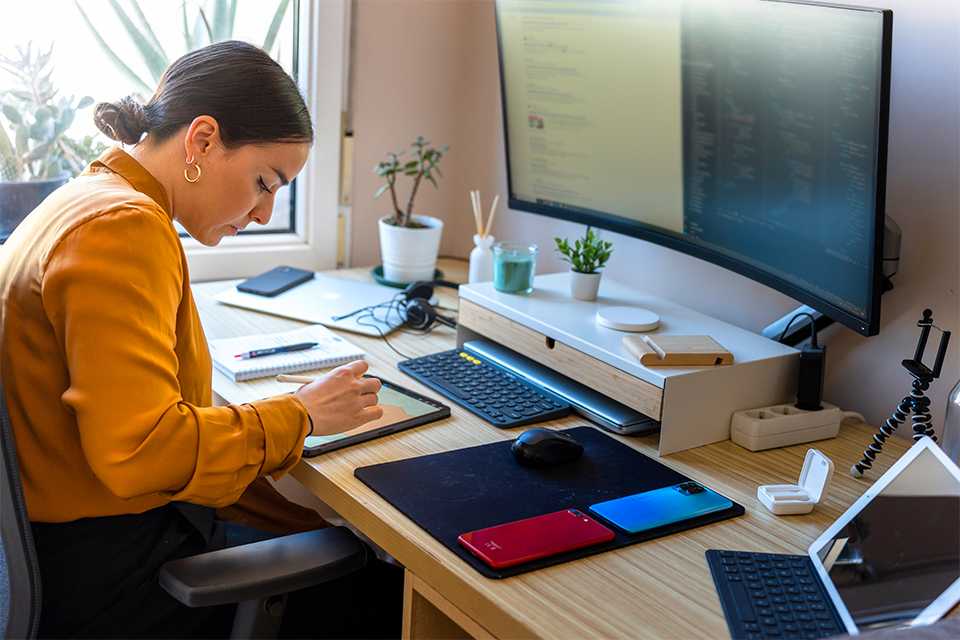 A man working on his desktop connected to TP-Link mesh Wi-fi system in a home office setup.