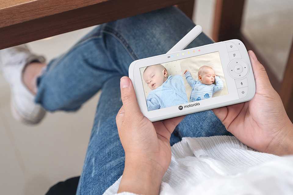 A mother checking her baby through a Motorola Nursery VM35 2 video monitor.
