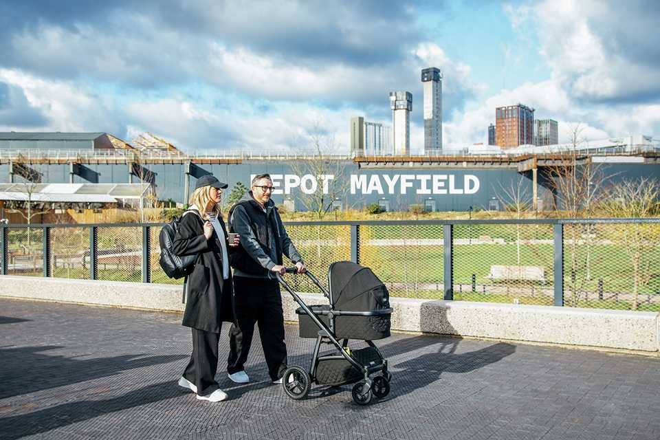 Parents walking while taking their baby out in a Cosatto Wow 3 Pram and Pushchair.