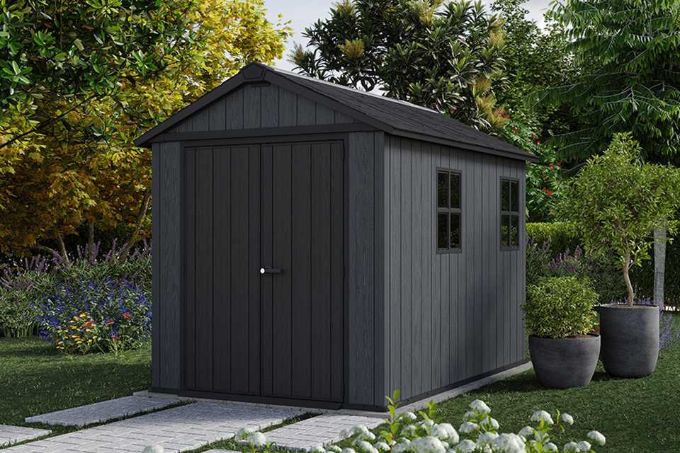 Keter Newton Plus Plastic shed surrounded by trees and plants.