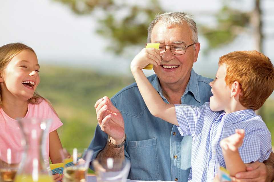 Two kids playing Moose Do You Really Know Your Family Board Game with their grandfather.