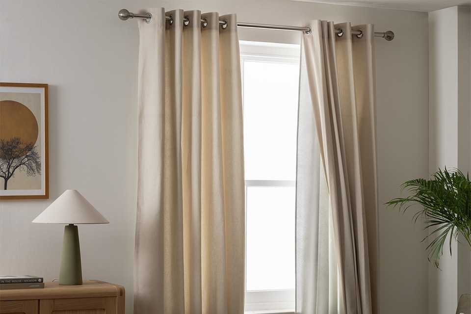 Argos Home white eyelet curtains in a living room.