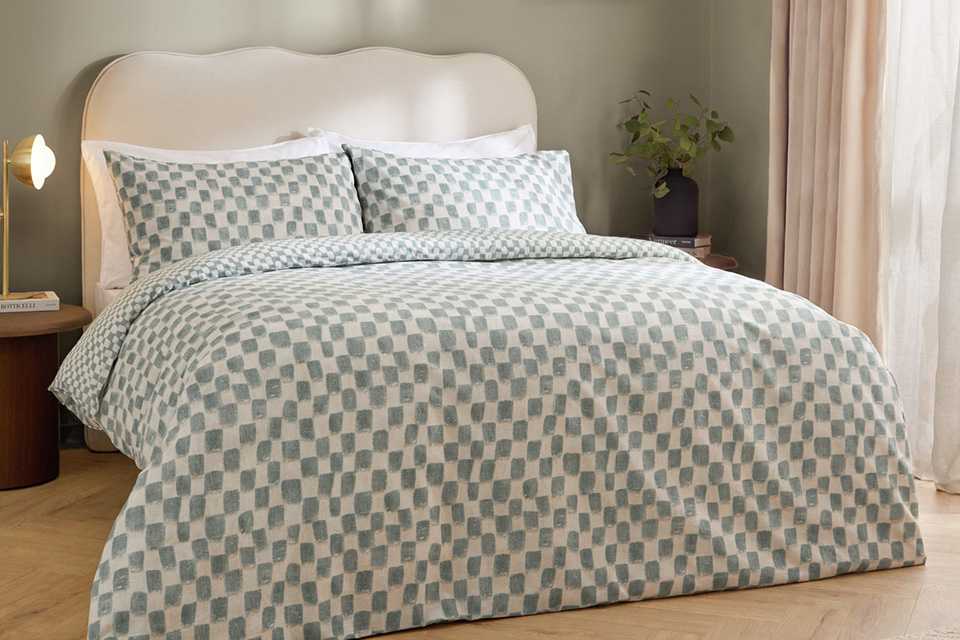 A bed made with a Hoem Nyhavn Aqua single bedding set.