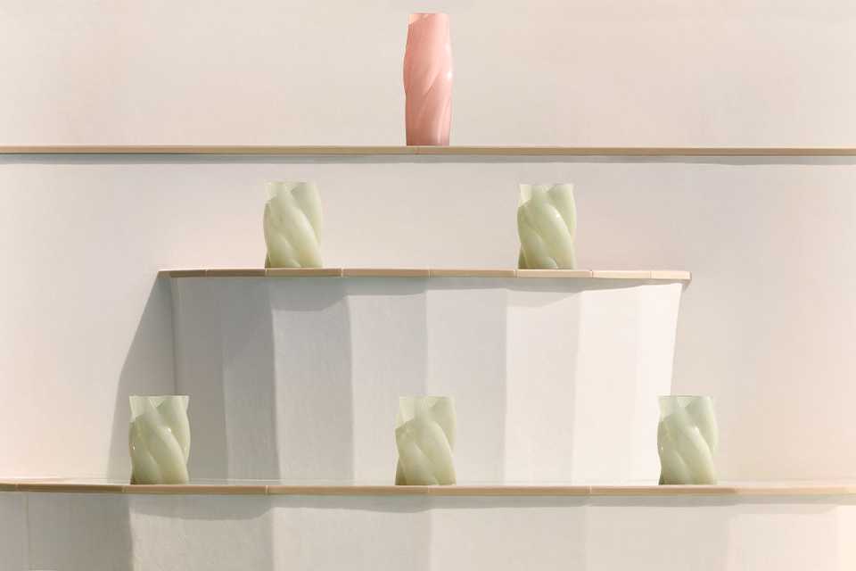 Habitat vases in white and pink placed on and around a white table next to a pool.