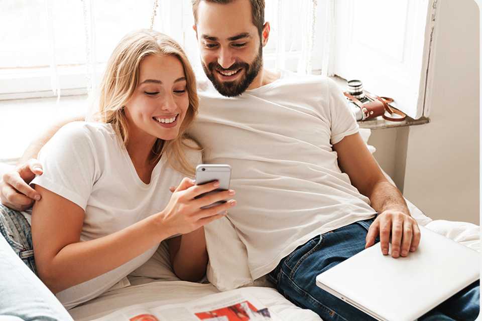 A man and a woman looking at a smartphone together.