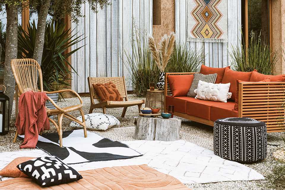 Wicker and orange garden furniture in garden.
