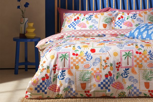 An Argos Home Sorrento Cotton Bedding Set on a bed in a blue and off-white coloured bedroom.