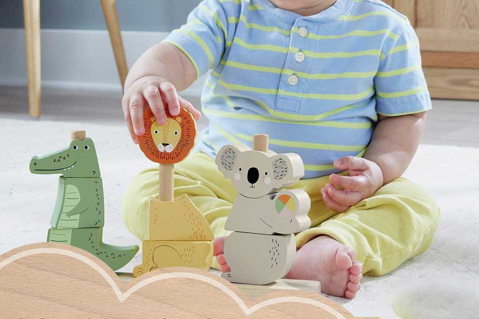A child playing with a Fisher-Price Wooden Stack & Sort Animals 10 Piece toy.