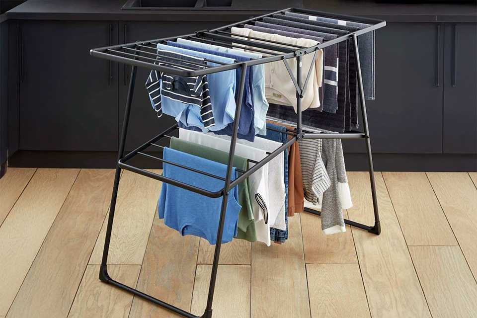 A Swan Stealth winged easy close airer with many clothes drying on it.