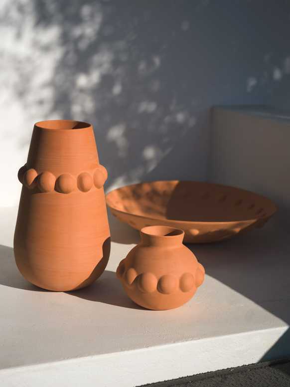 2 Habitat terracotta vases and a terracotta bowl placed outdoors.