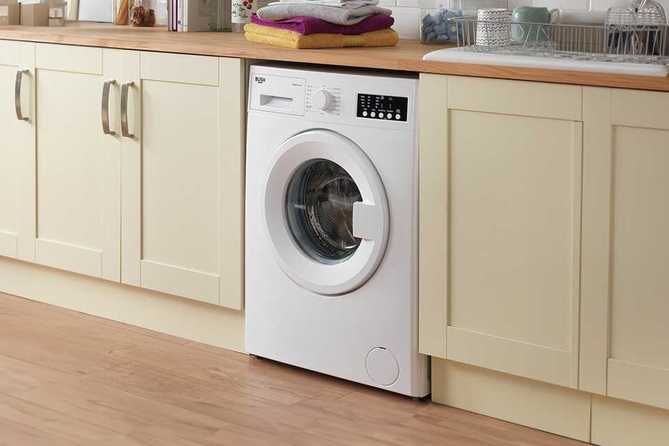A Bush 7KG white washing machine in a utility room.
