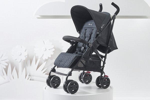 A blue Silver Cross Pop stroller placed on a while round platform.