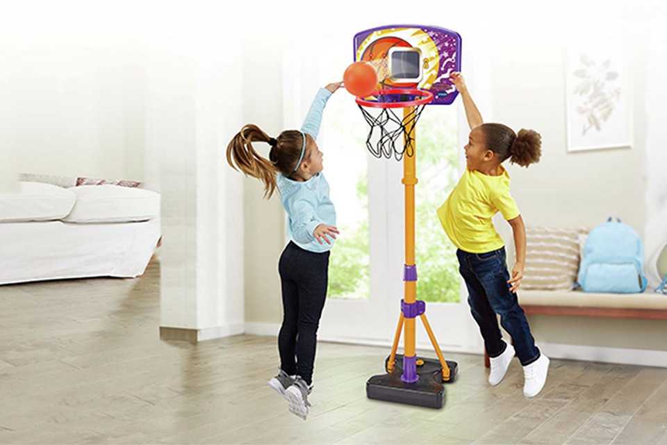 Two girls playing with a Vtech Counting Hoops basketball stand.