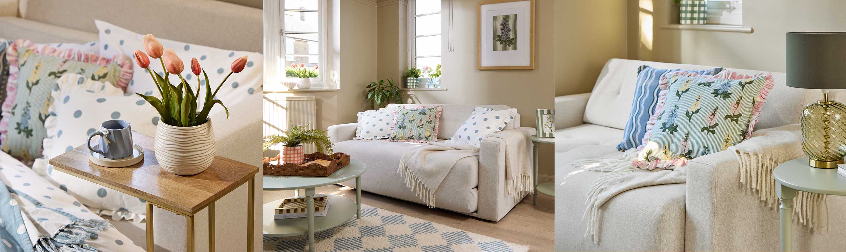 A vase of tulips on a side table, a round coffee table in front of a sofa, and throw pillows on a sofa near a side table.