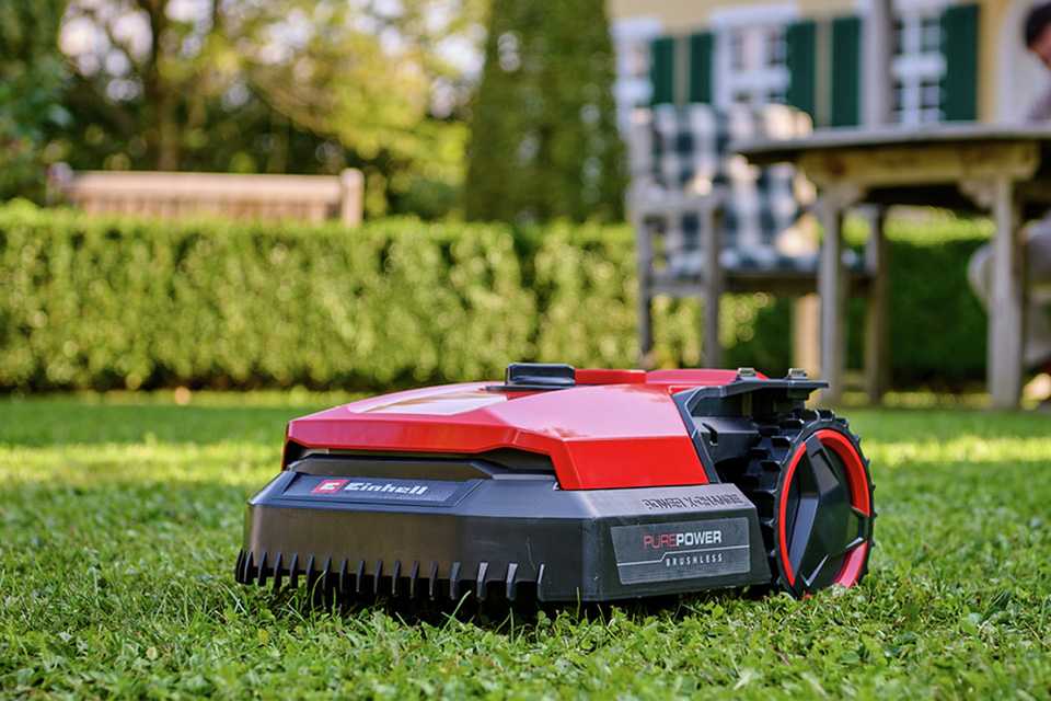 A person using an Einhell robotic lawnmower to mow their lawn.
