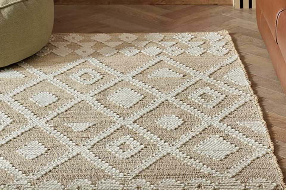 A Habitat Woven Aztec Neutral Jute Flatweave Rug in a room.