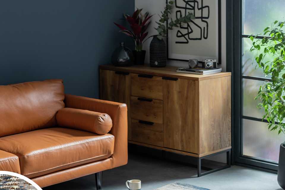 A Habitat Distressed Abstract Blue Flatweave Rug and a tan brown sofa in a living room.