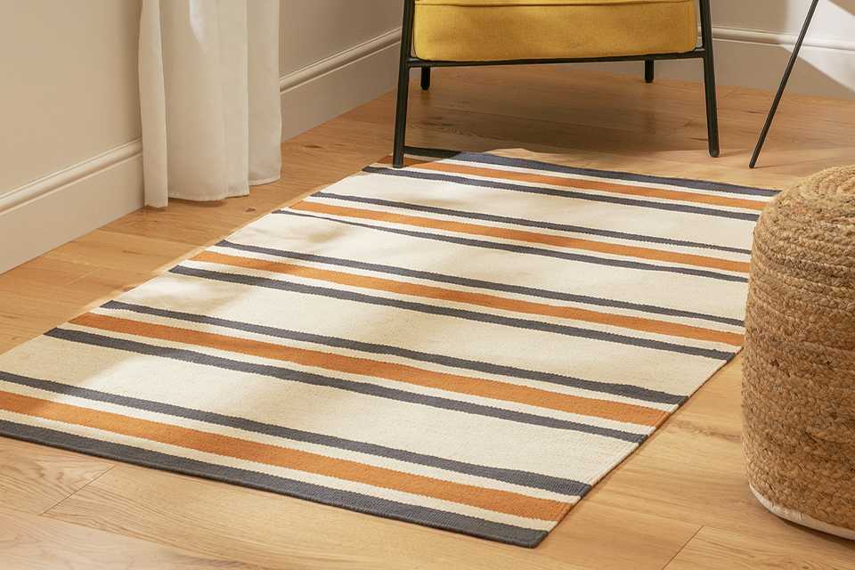 A mustard chair on a Habitat Stripe Charcoal Flatweave Rug.