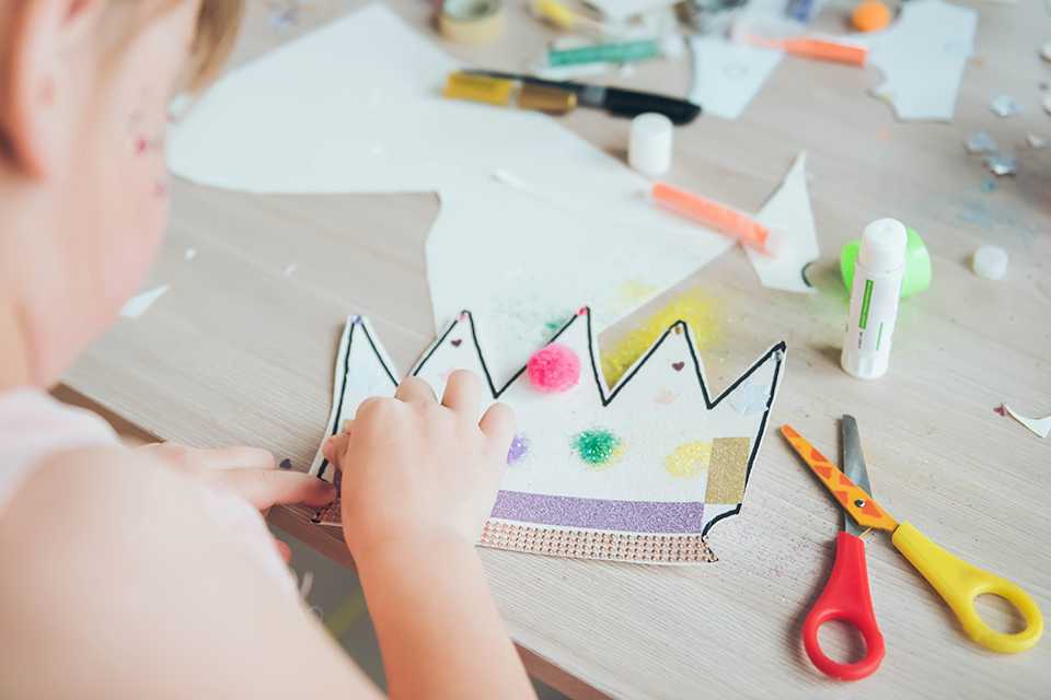 A girl making a paper crown.